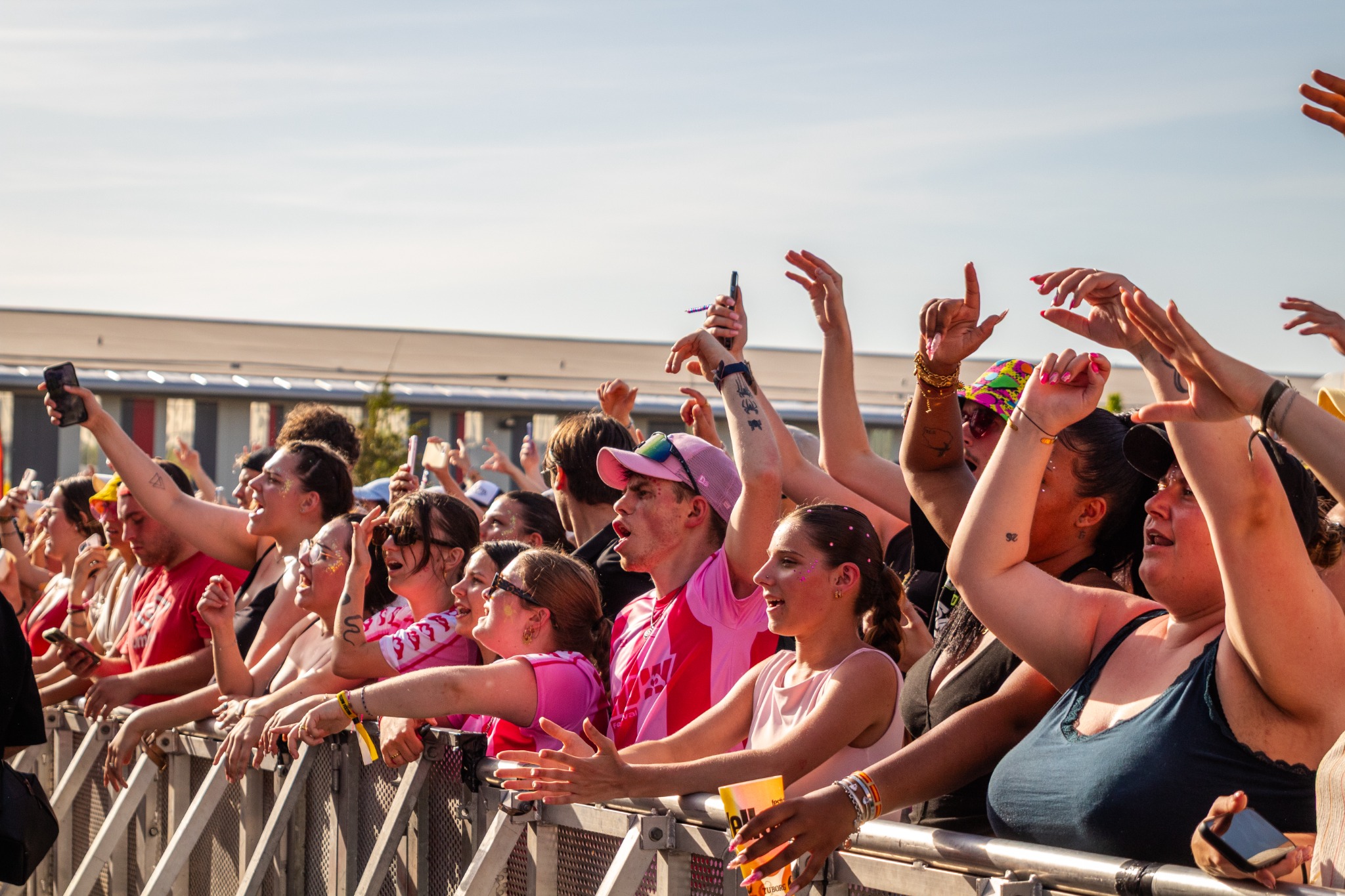 Festivaliers au premier rang du Yellow Festival, les bras levés