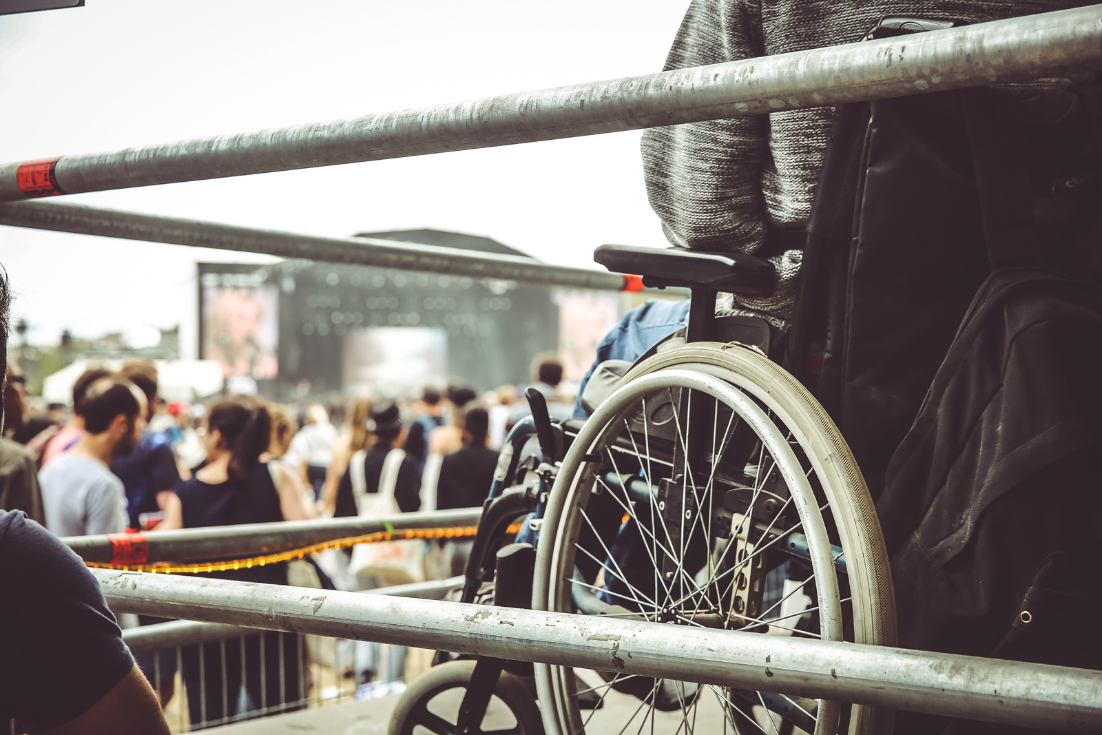 Une personne en fauteuil roulant assiste à un concert depuis un espace surélevé