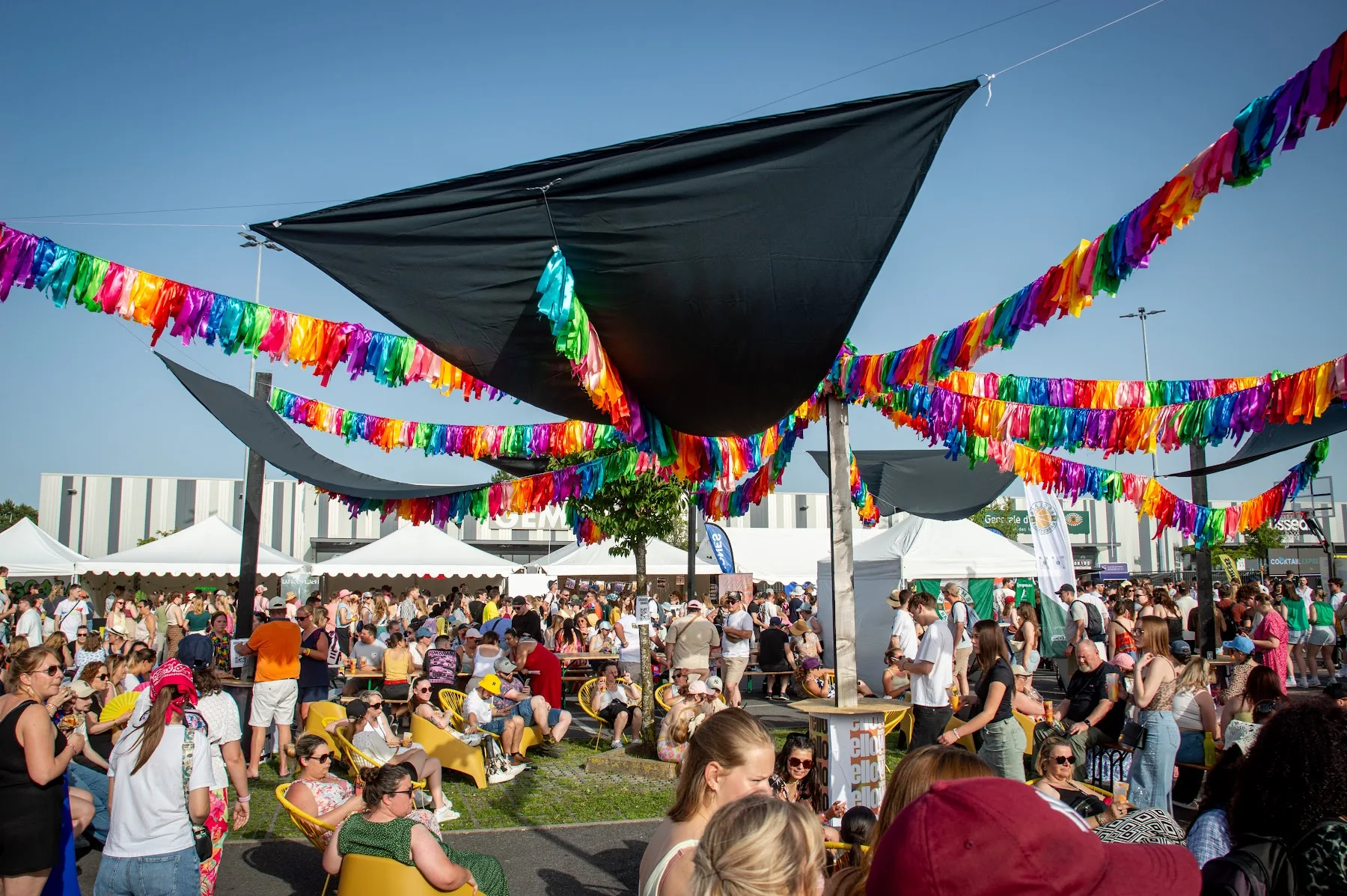 Les tables et les guirlandes colorées du village — Yellow Festival 2026